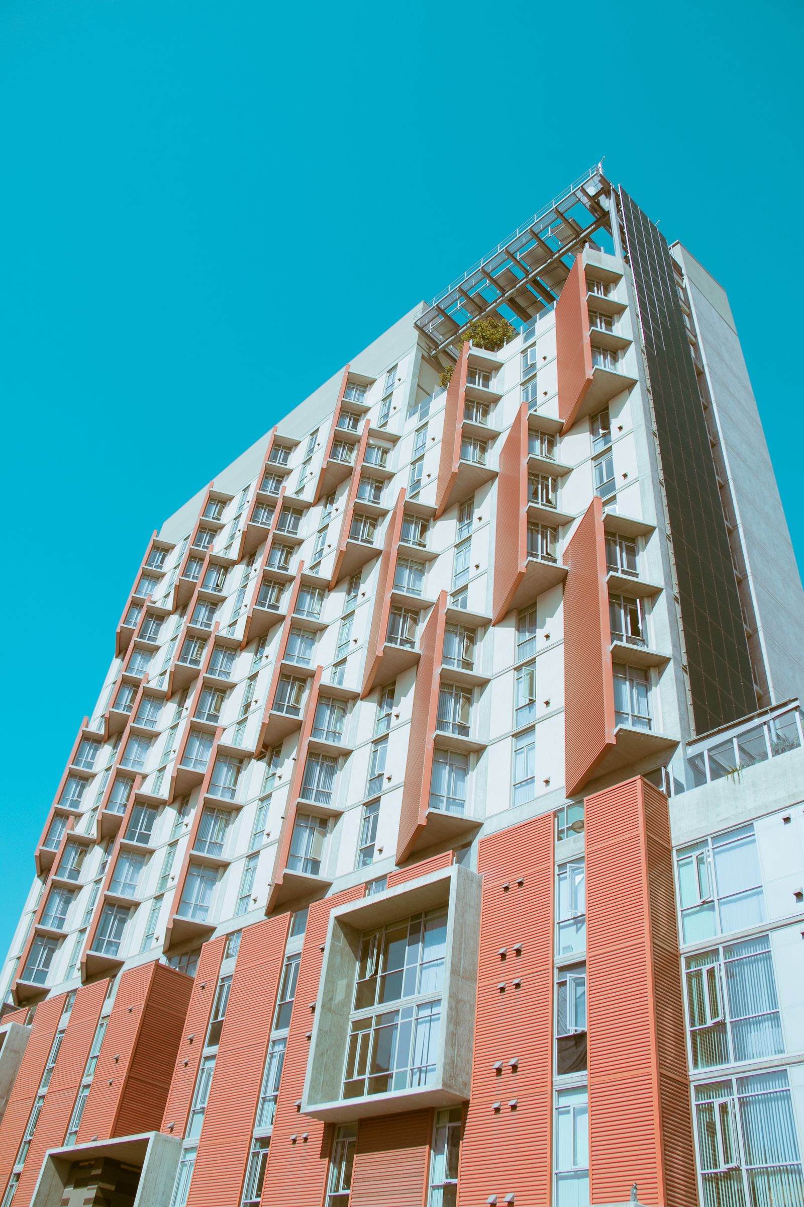 San Diego apartment building with balconies and a red and white facade